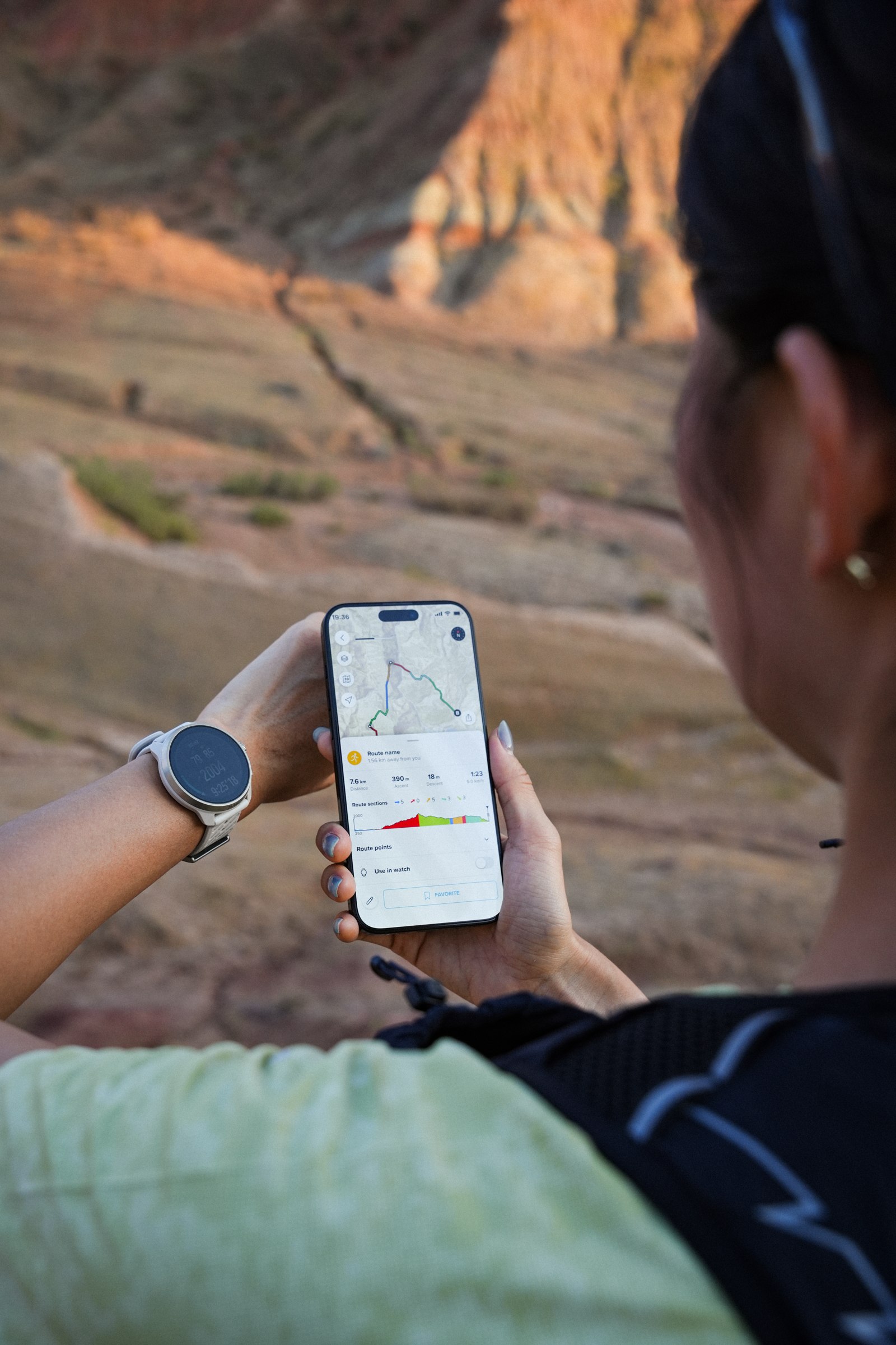 Löpare planerar en rutt i Suunto-appen med bergen framför sig